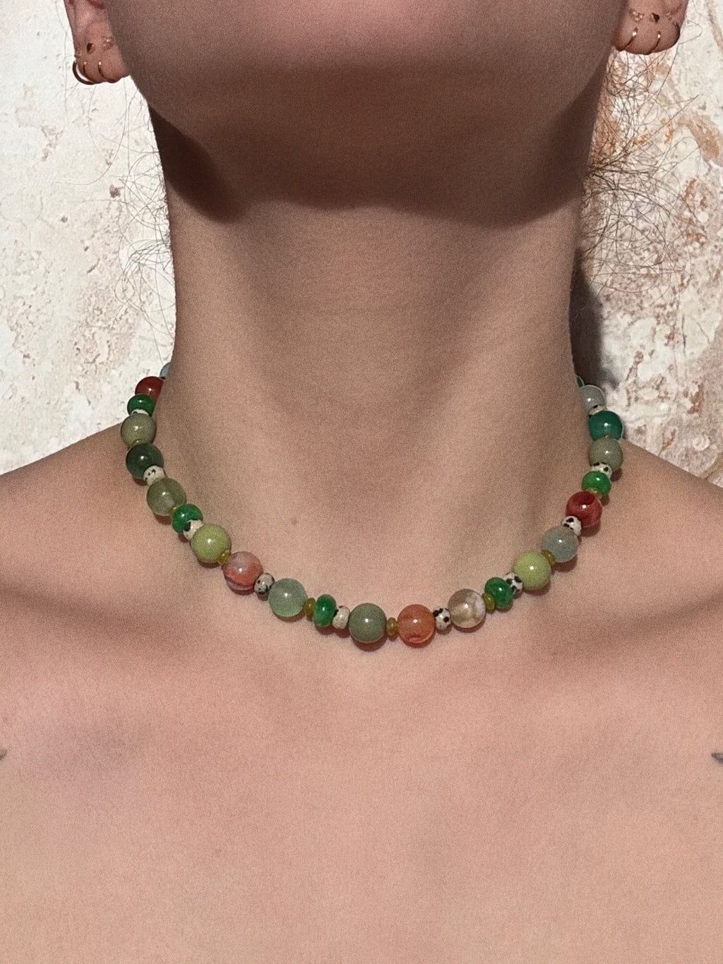 Rachel necklace with coloured flower agate, jade, glass and jasper beads worn by a model against a neutral background