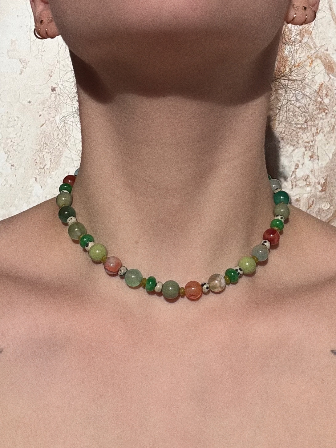 Rachel necklace with coloured flower agate, jade, glass and jasper beads worn by a model against a neutral background