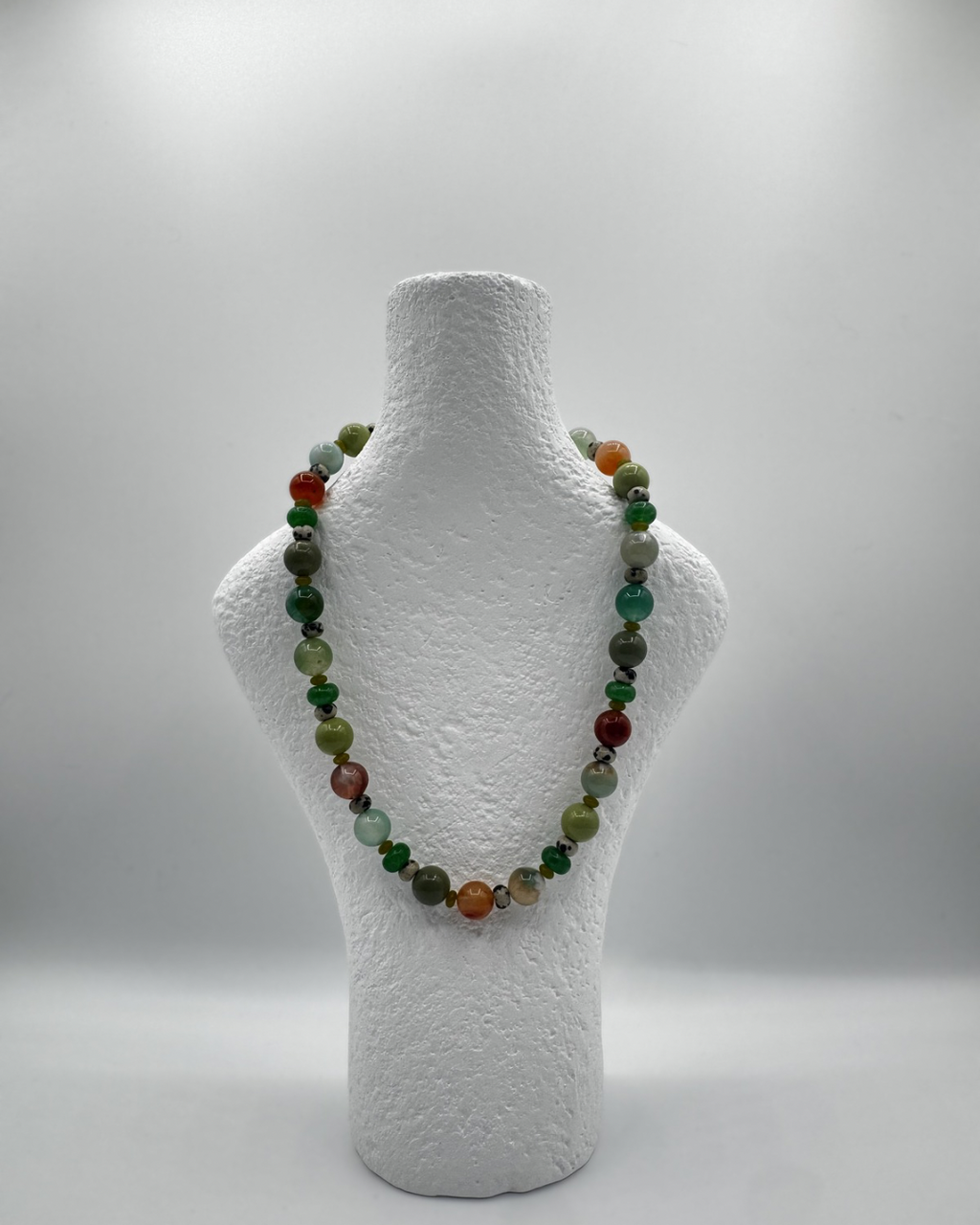 Rachel necklace with coloured flower agate, jade, glass and jasper beads on a white mannequin bust against a white background