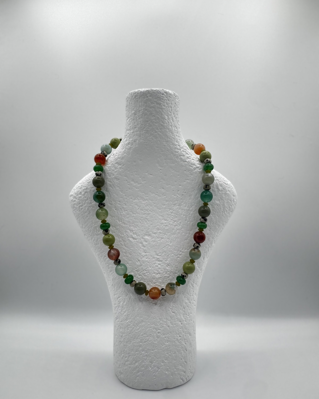 Rachel necklace with coloured flower agate, jade, glass and jasper beads on a white mannequin bust against a white background
